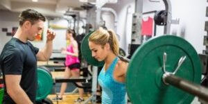 Fit-woman-lifting-heavy-barbell-in-weights-room-at-the-gym